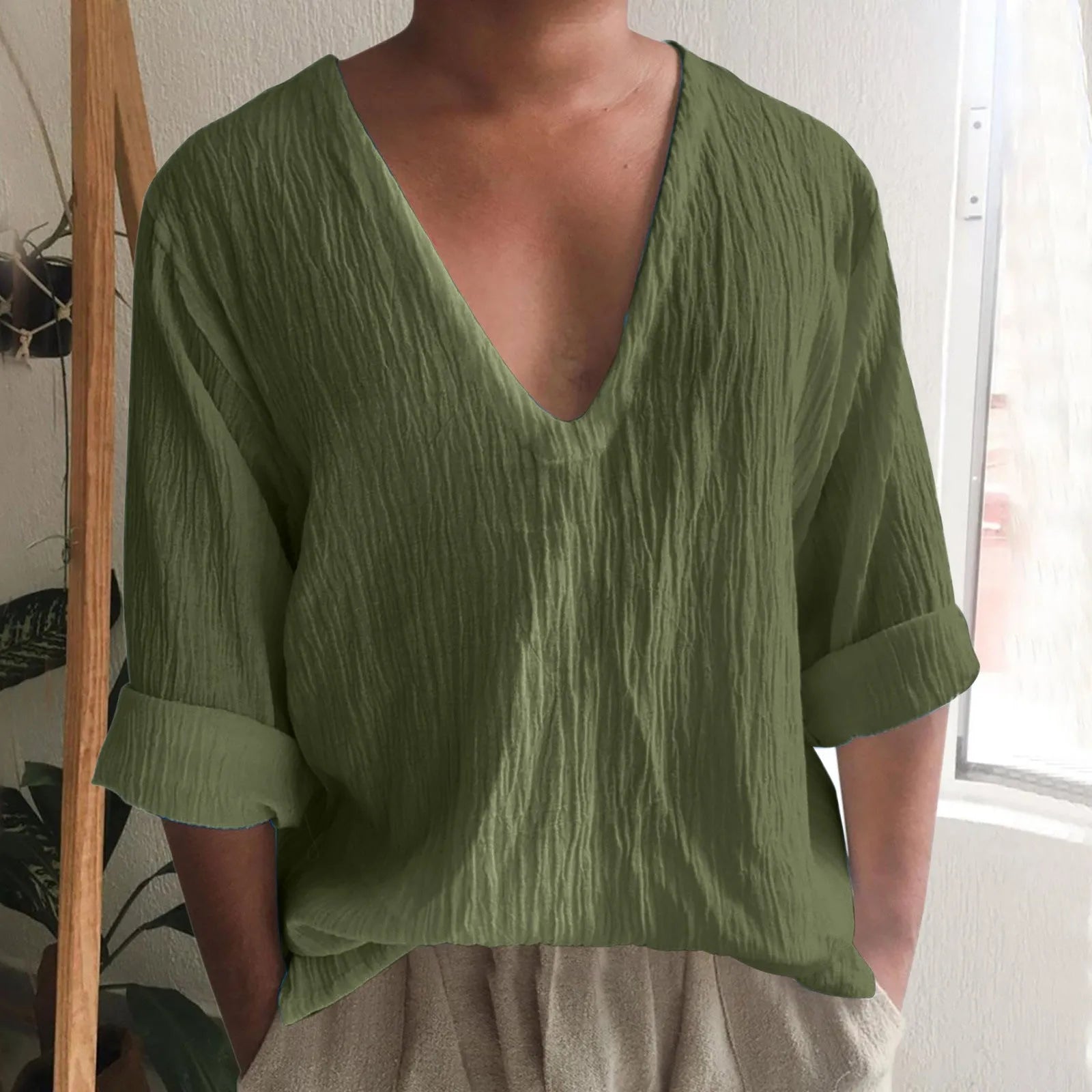 Man wearing a washed cotton long sleeve V-neck t-shirt in a solid colour.