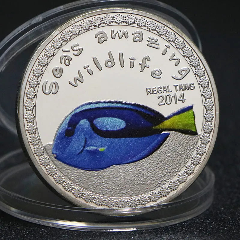 Set of eight silver plated commemorative coins with tropical fish and marine animal designs, 40mm diameter, in acrylic box