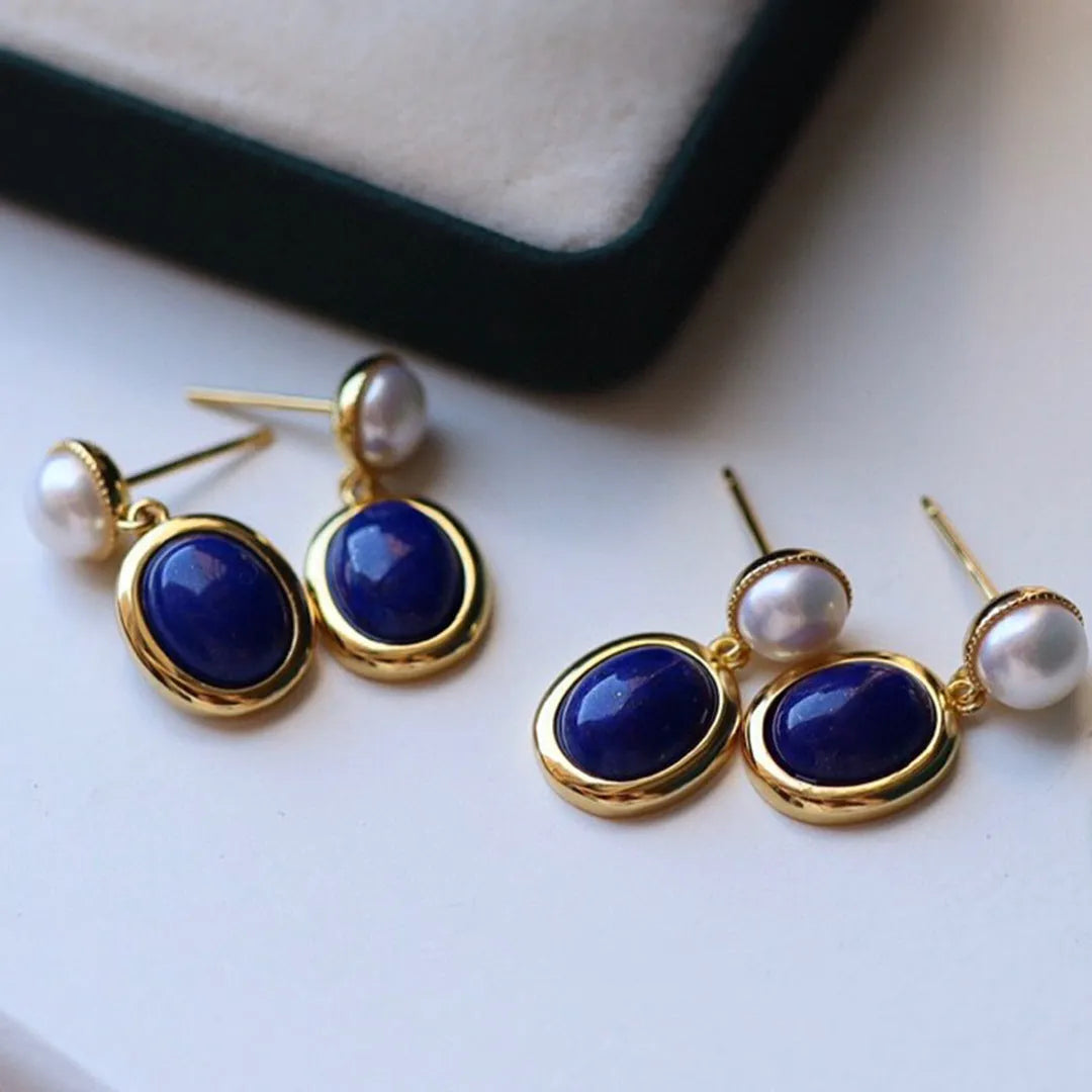 A pair of simple sterling silver earrings featuring deep blue lapis lazuli pearls.