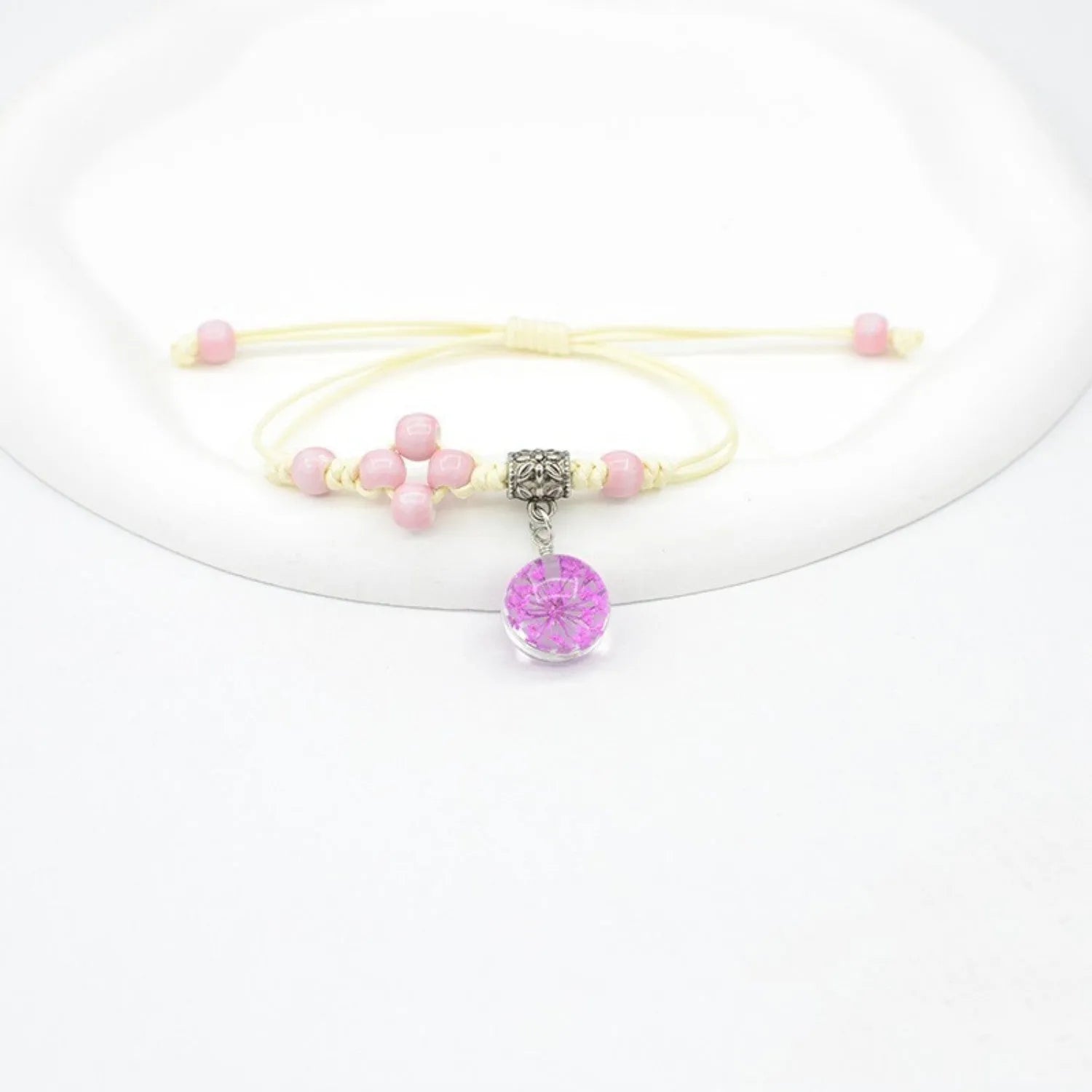 Hand-woven glass bracelet with large beads containing real dried flowers, shown in multiple colour options.
