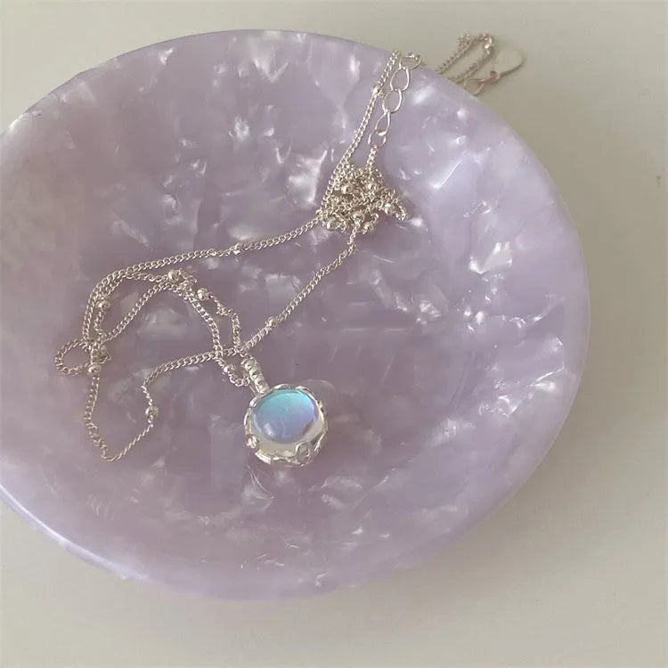 Women's silver necklace with a geometric stone pendant on a curb chain.