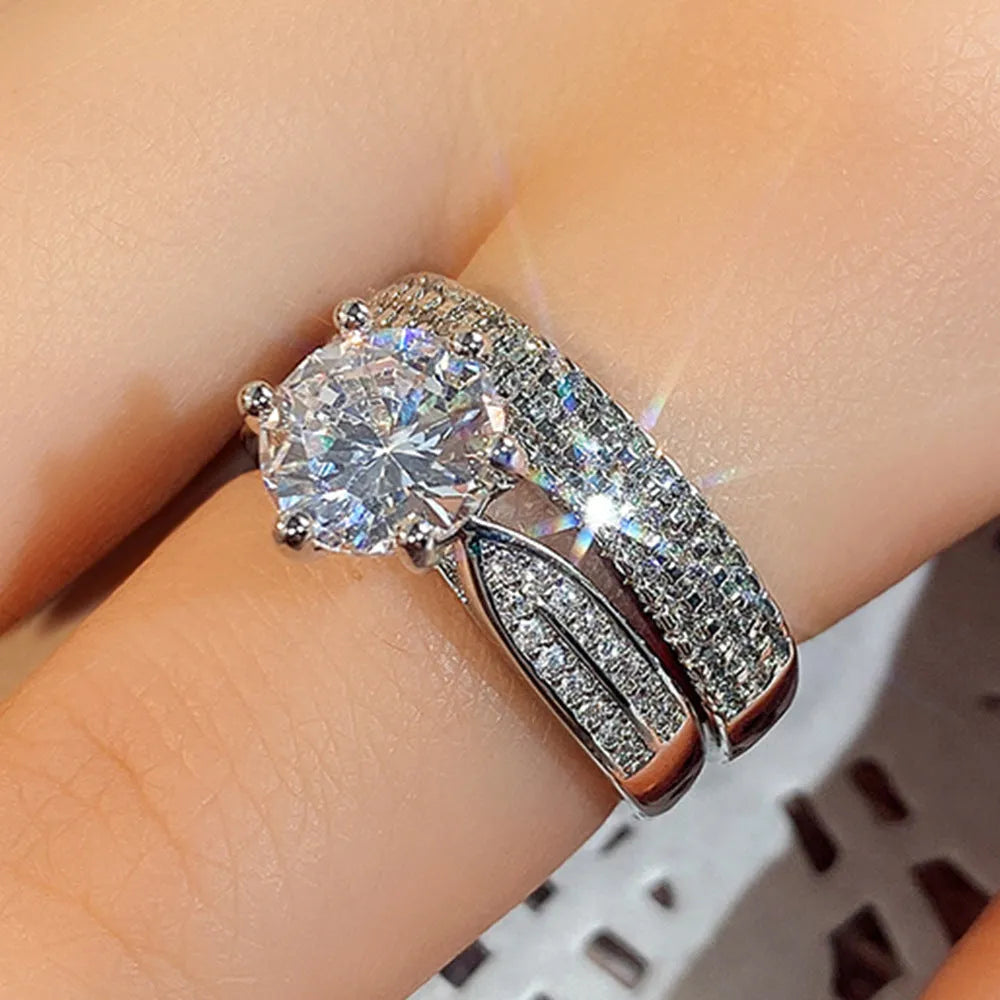 White gold colour geometric wedding ring with round details on a plain background.