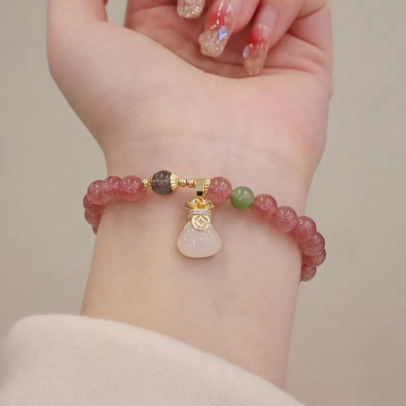 Geometric strawberry quartz women's bracelet with a lucky bag charm and silver safety buckle on a white background.