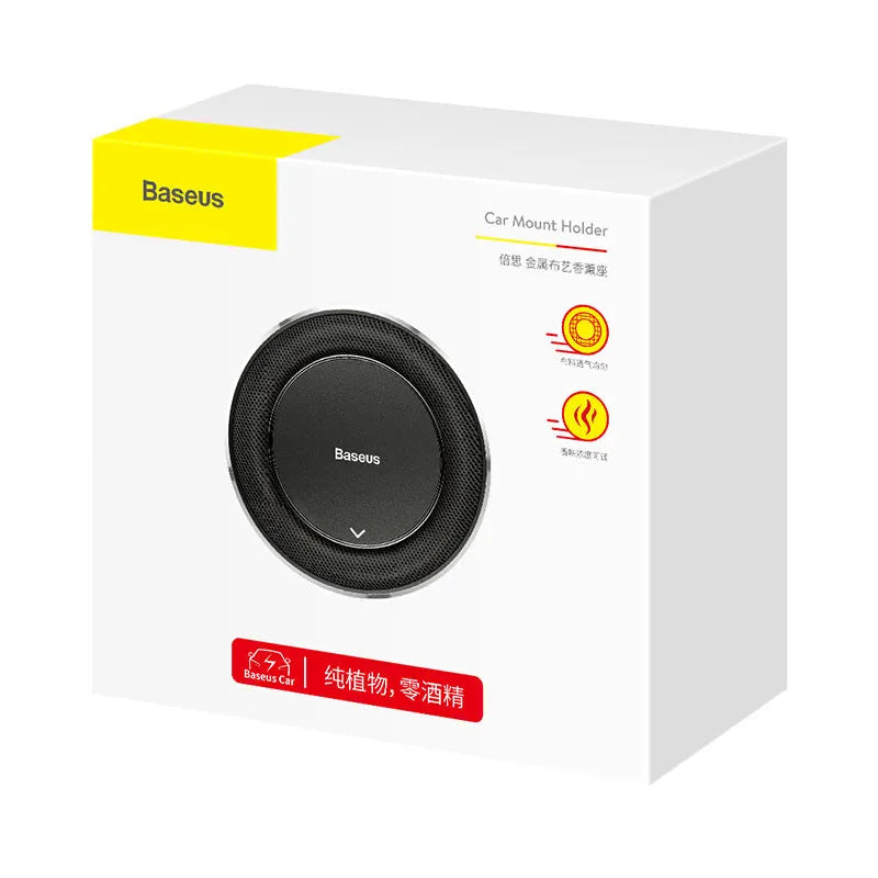 Round black aluminium alloy Bess car fragrance unit placed on a car seat.