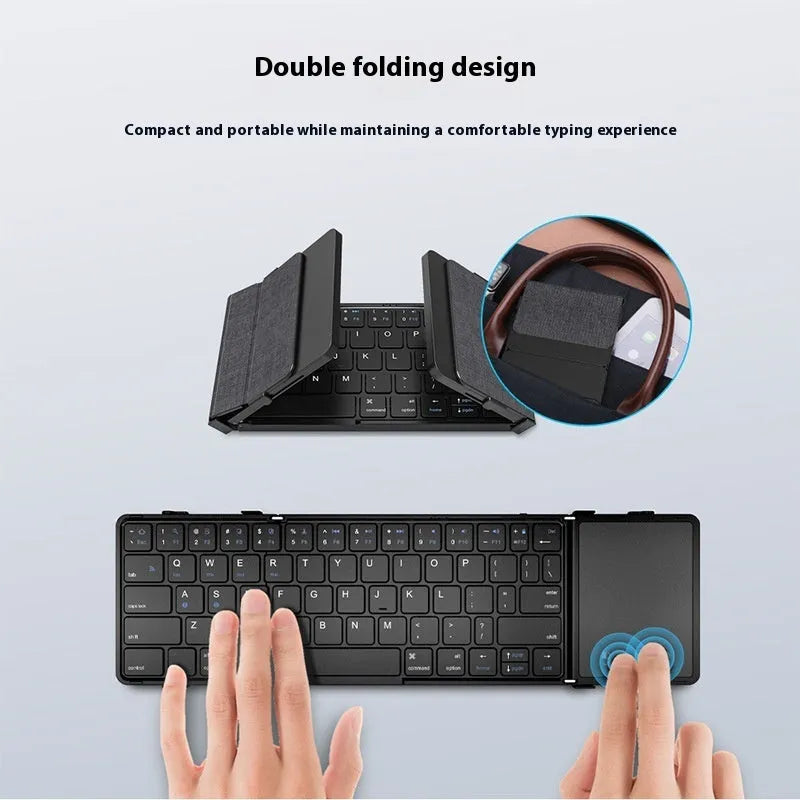 Black folding Bluetooth keyboard showing compact folded size beside mobile phone