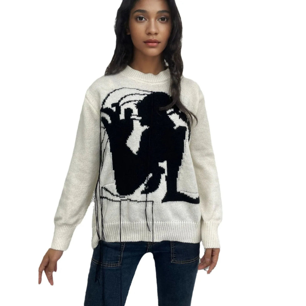 Grey women's alpaca wool sweater with abstract pattern and tassel detailing on a hanger.