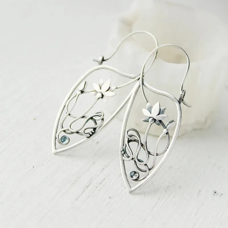 Silver geometric lotus vine earrings with rhinestone accents on white background