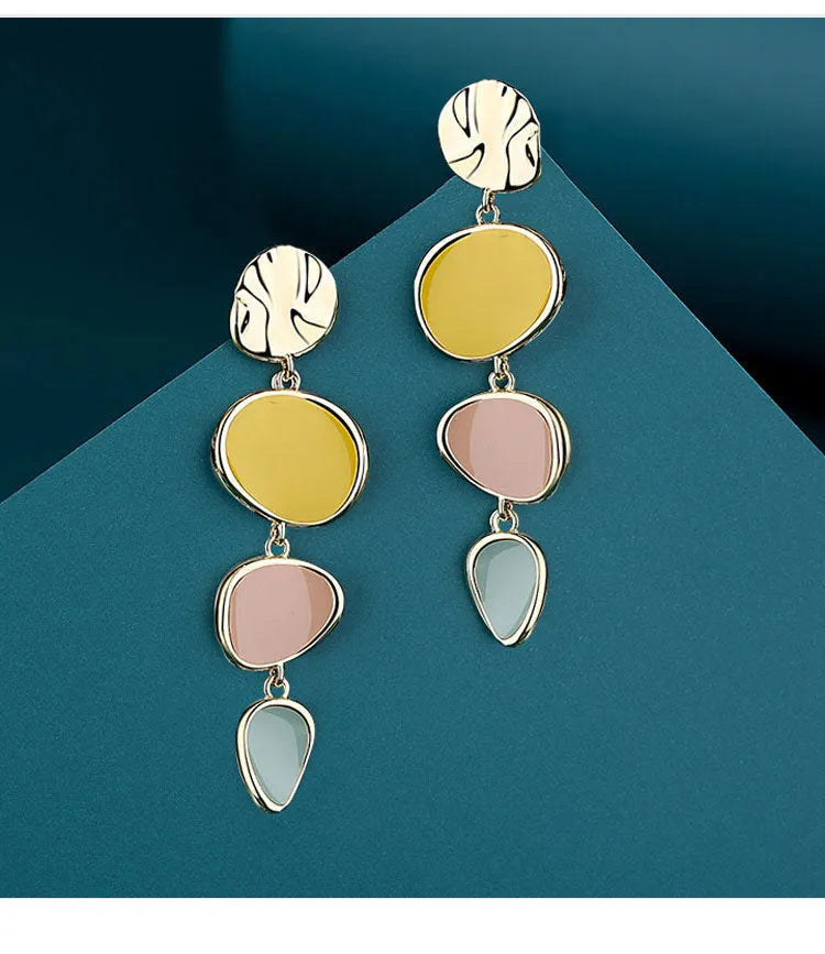 A pair of simple disc-shaped alloy earrings with a Morandi three-colour oil-drip wash finish.
