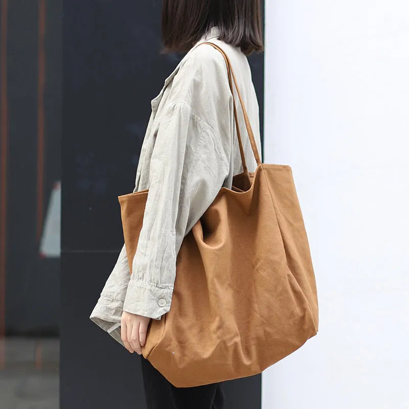 Large canvas shoulder tote bag in solid colour with soft handle, open top, and internal phone pocket