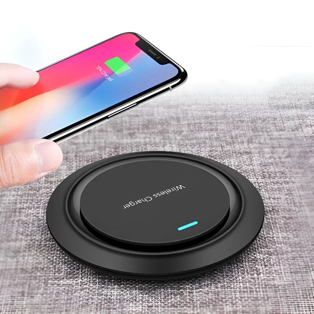 A round, slim 7mm thick 10W desktop wireless phone charger in black or white on a desk.