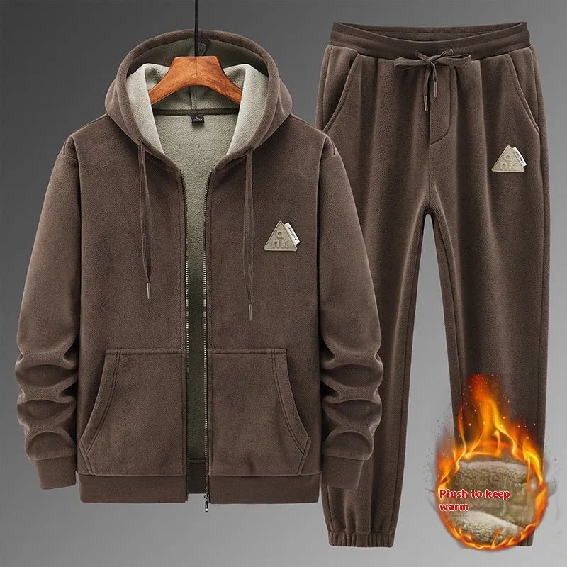 Man wearing a grey hooded sweatshirt and matching tracksuit pants from a casual two-piece set.