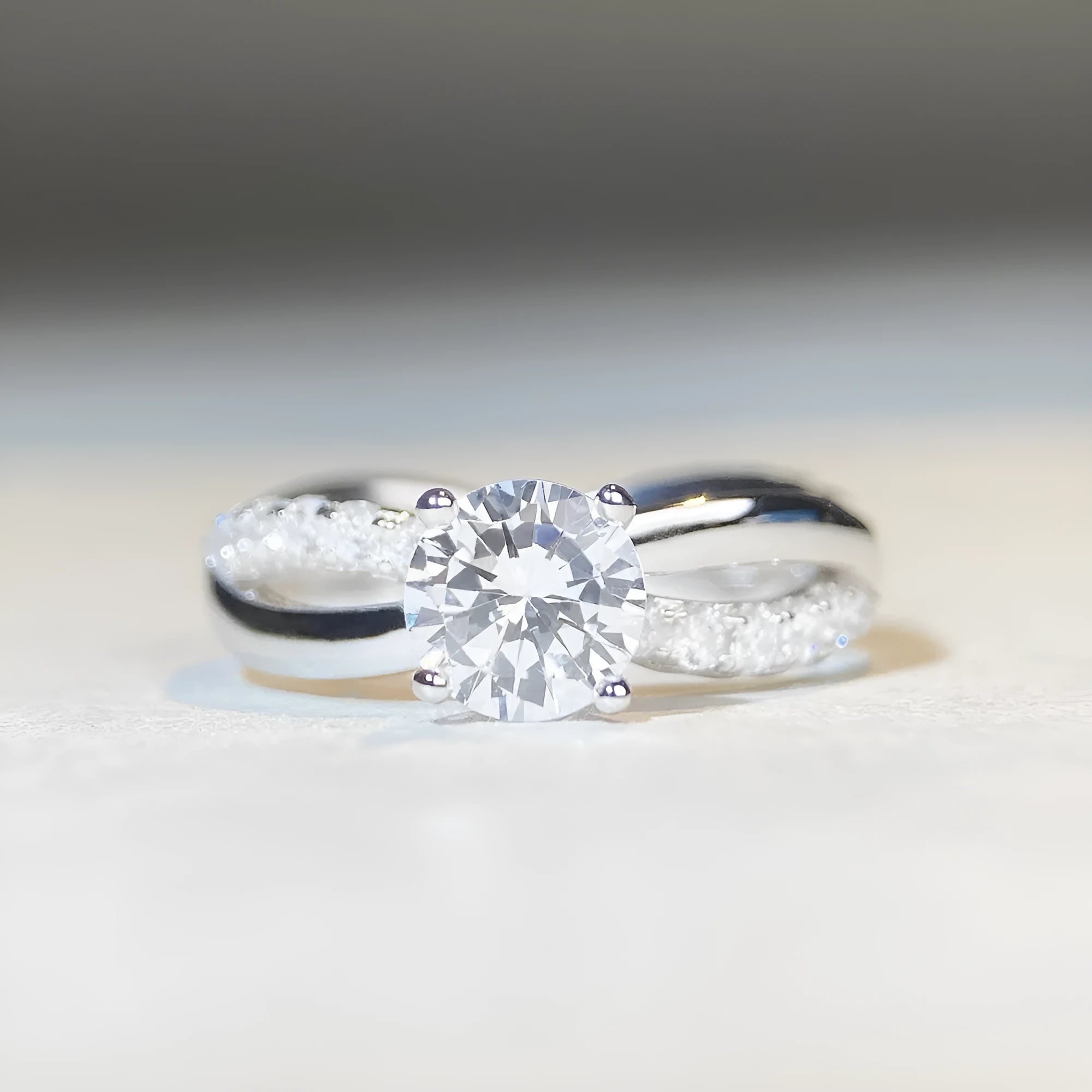 Geometric cross design silver ring with a 1 carat moissanite stone and twisted arm winding.