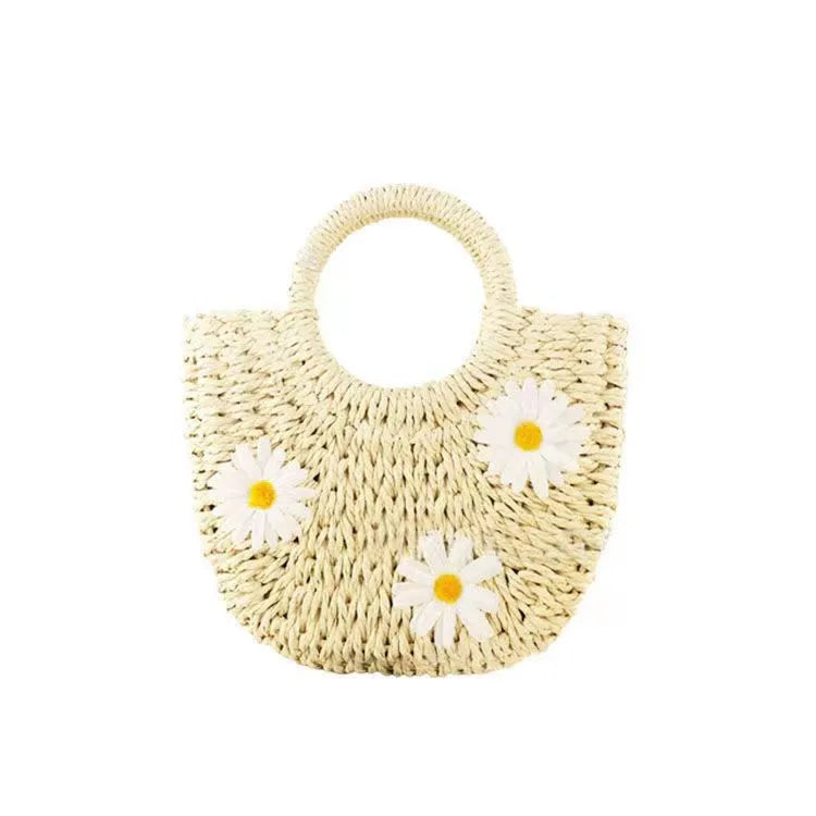 Light brown straw-weaved women's crossbody bag with daisy pattern, showing woven texture and crossbody strap