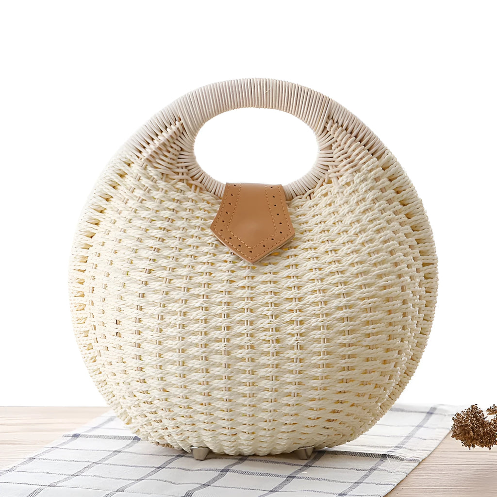 Women's round woven paper rope handbag in beige with hard shell, cover closure, and hard handle