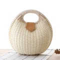 Women's round woven paper rope handbag in beige with hard shell, cover closure, and hard handle
