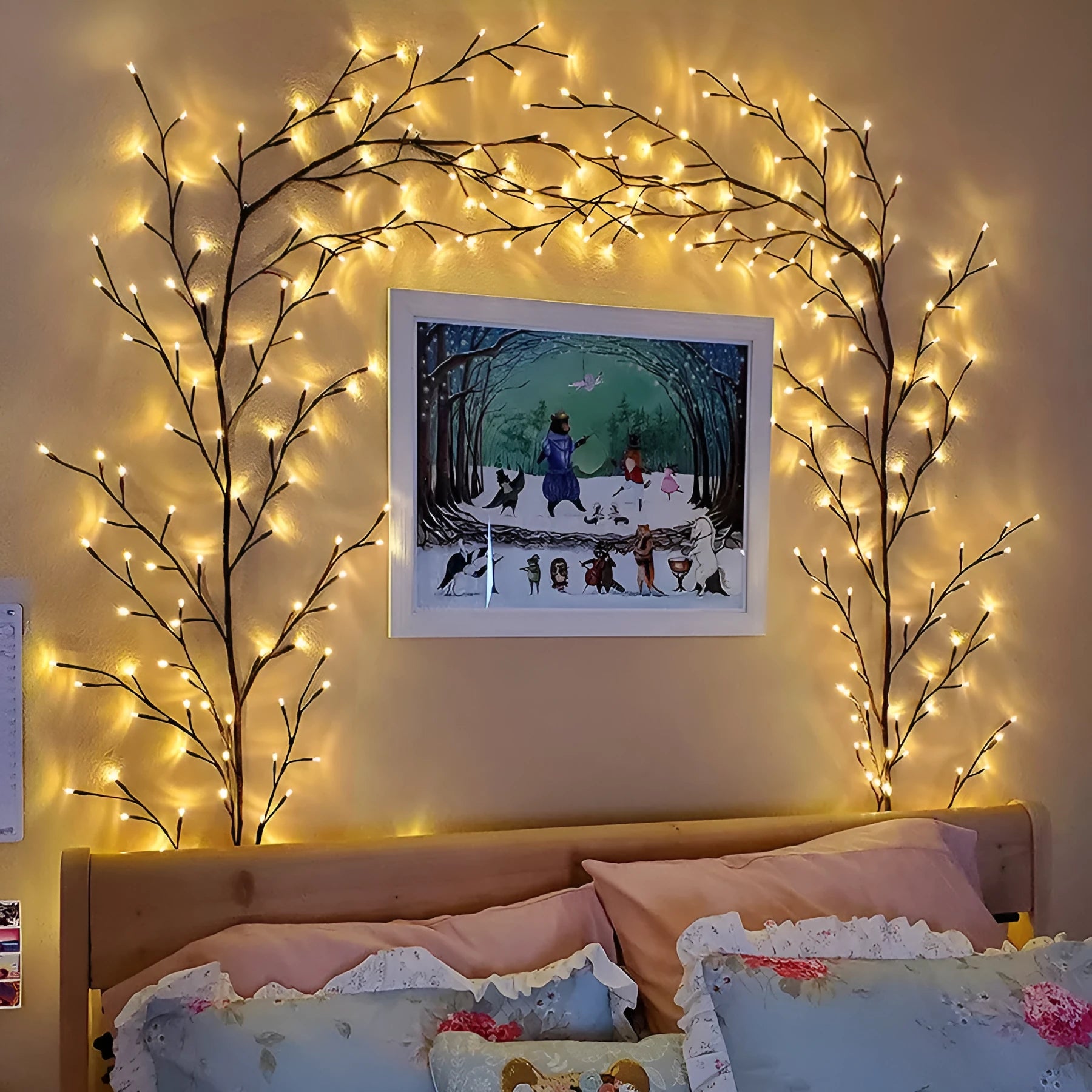 Flexible plastic LED willow vine garland with warm white lights bent into a decorative shape on a wall.