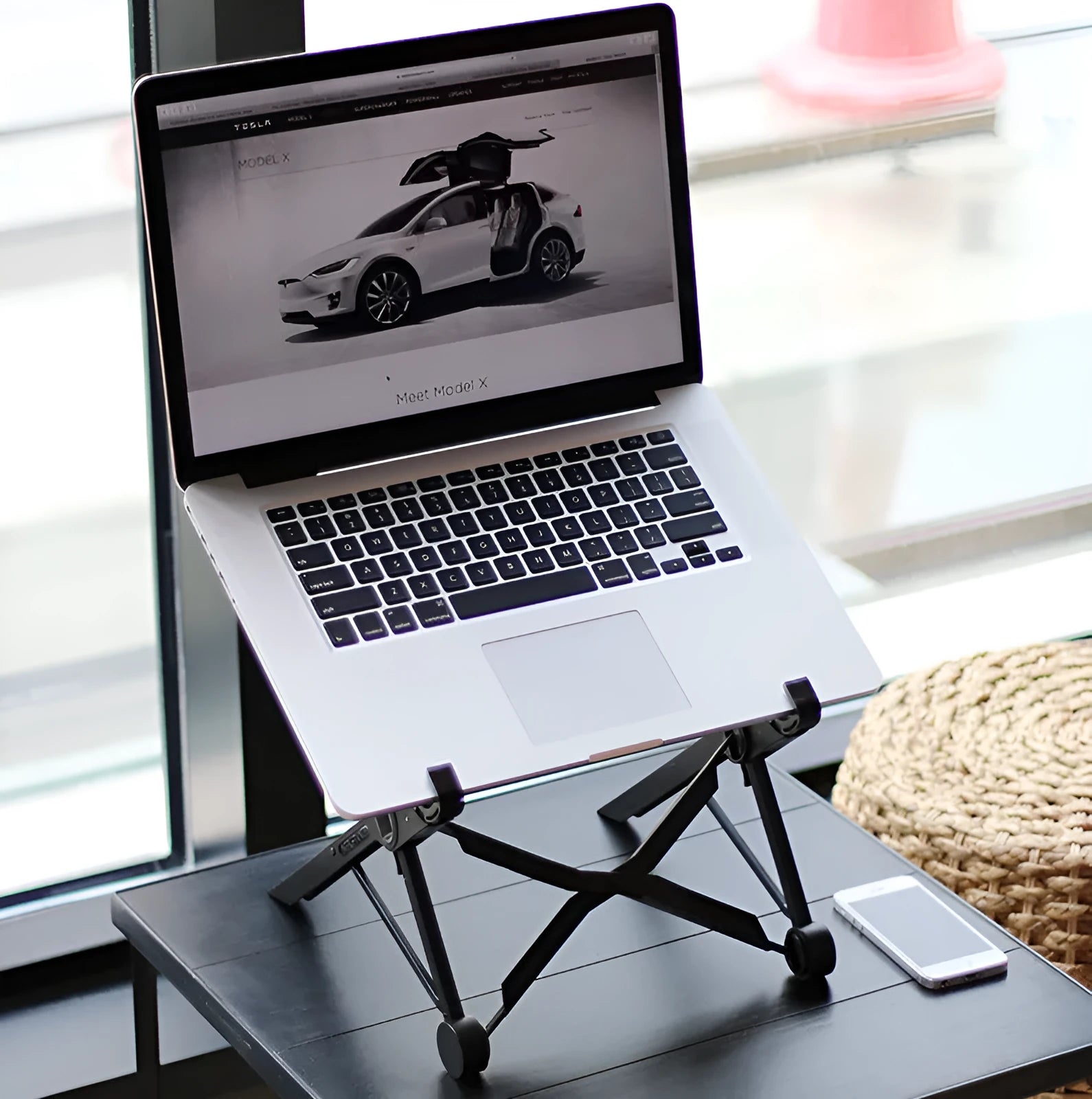 Black folding portable laptop stand made of reinforced nylon, shown open and folded to 4cm depth.