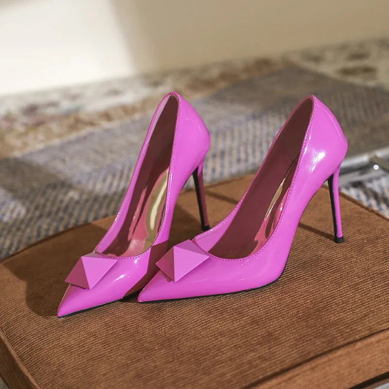 Pink patent leather women's stiletto heels with an ankle buckle and pointed toe.