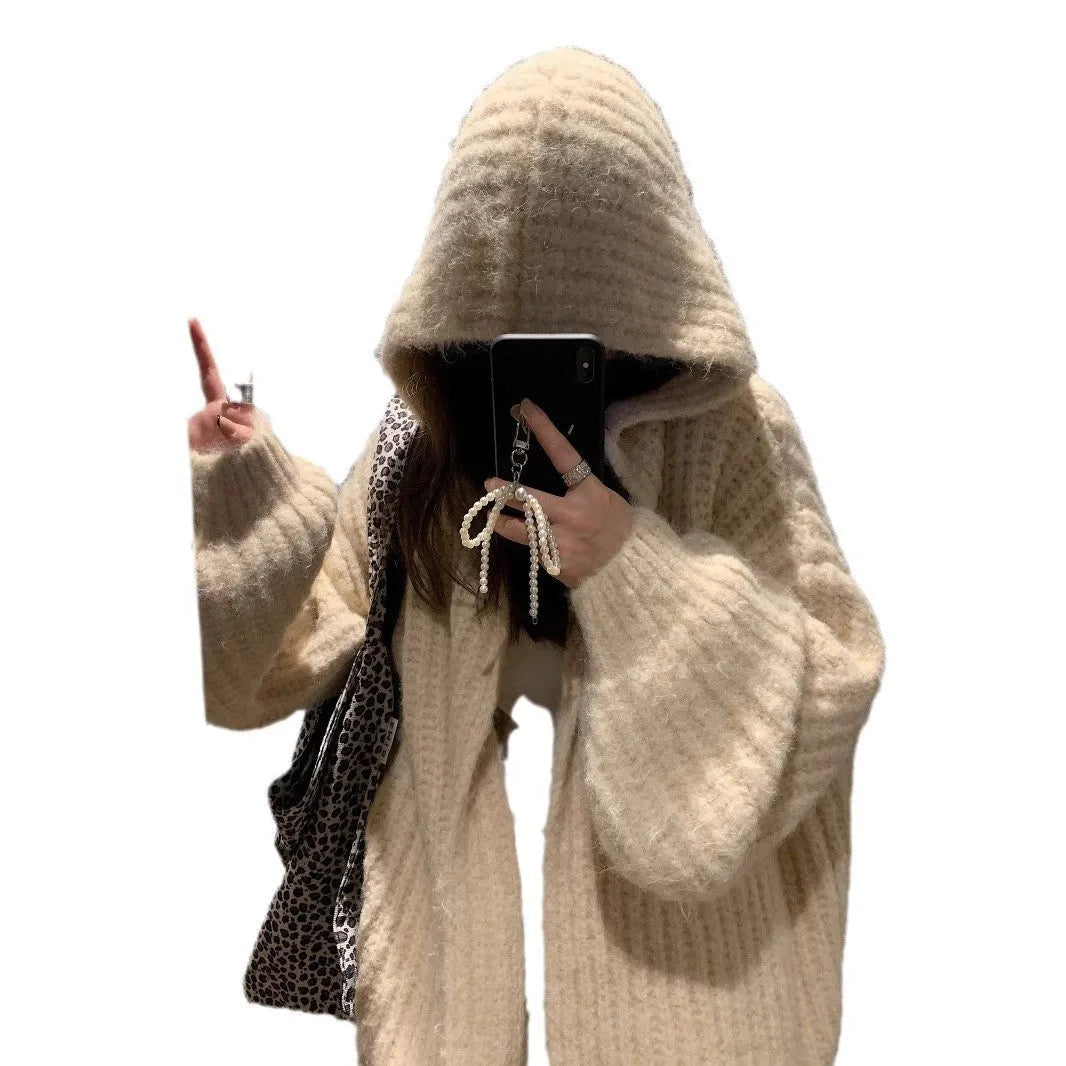Woman wearing a brown retro-style chunky knit hooded cardigan with a loose fit.