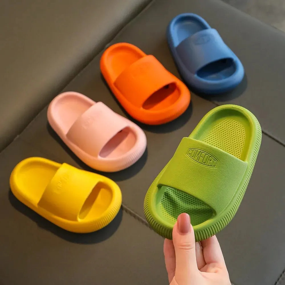 Colourful children's EVA slippers with textured sole, shown in blue, green, orange, pink, and yellow.