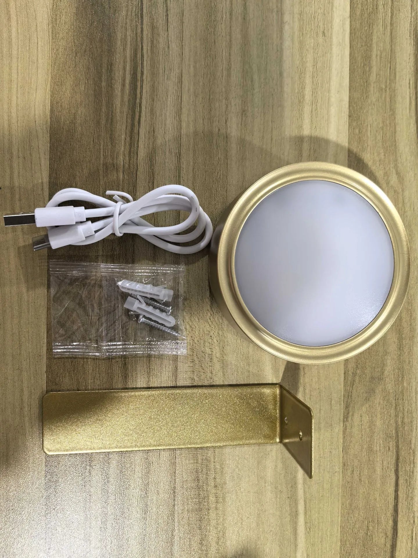 Black magnetic wireless LED lamp with remote control mounted next to a painting on a wall.
