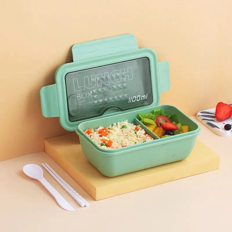 Green four-layer partitioned plastic bento lunch box with lid open.