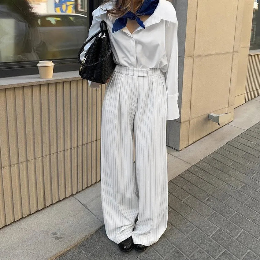 White striped wide-leg casual trousers with a zipper detail on a hanger.