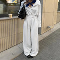 White striped wide-leg casual trousers with a zipper detail on a hanger.