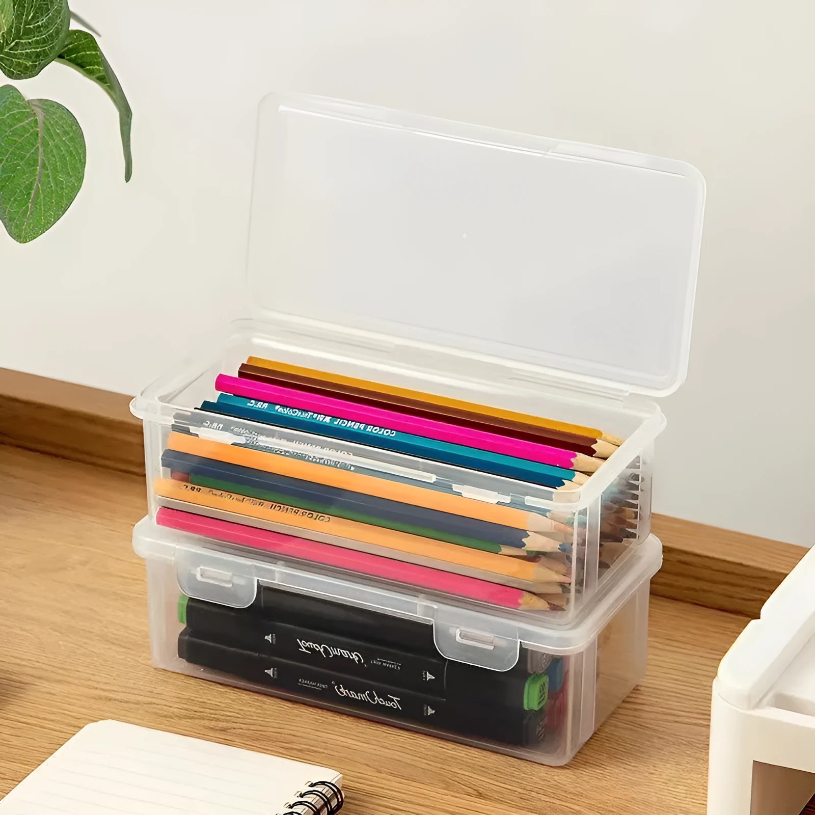 Large transparent plastic storage box full of coloured pencils and crayons