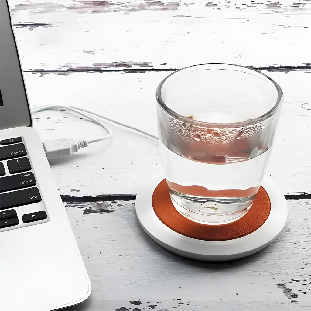 USB-powered insulated heating coaster in black, blue, and orange colours on a desk.