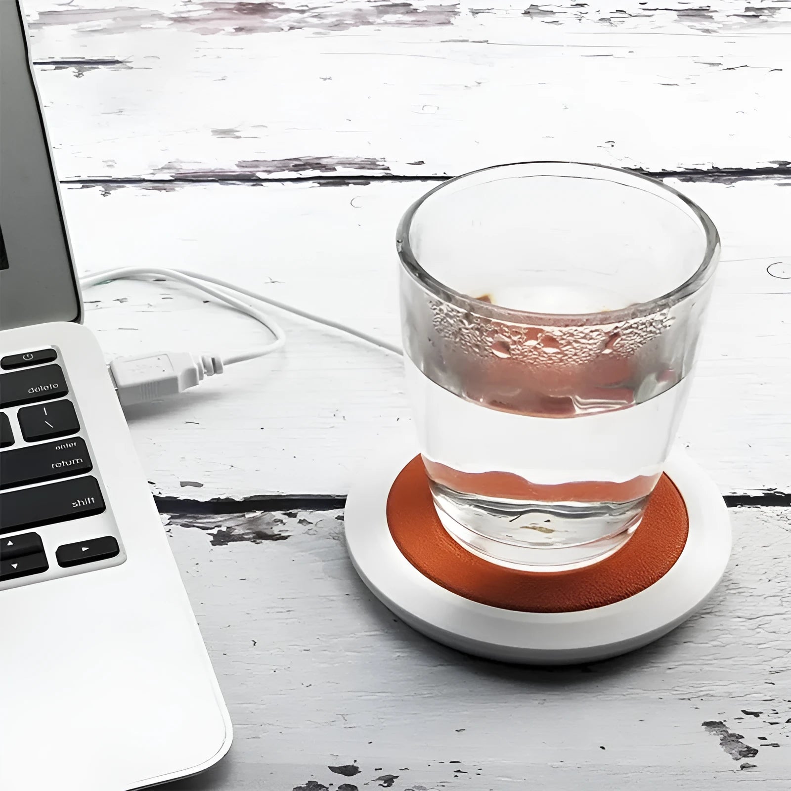 USB-powered insulated heating coaster in black, blue, and orange colours on a desk.