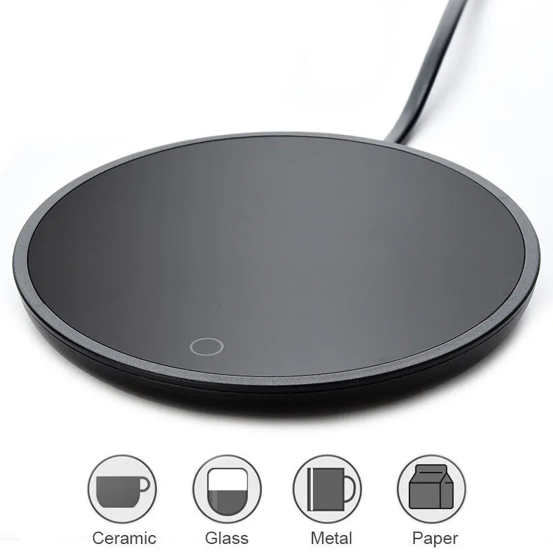 Black round desk cup warmer with tempered glass surface and low high switch on a wooden table.
