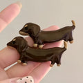 Dachshund dog shaped hair barrettes with electroplated finish, shown as a single clip or a pair.