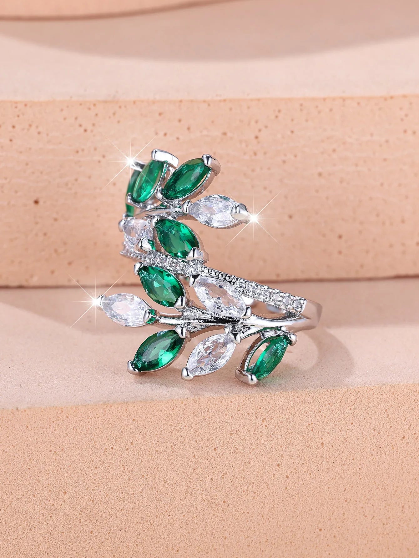 Adjustable copper leaf ring with a central zircon stone on a finger, showing rose gold and platinum colour options.
