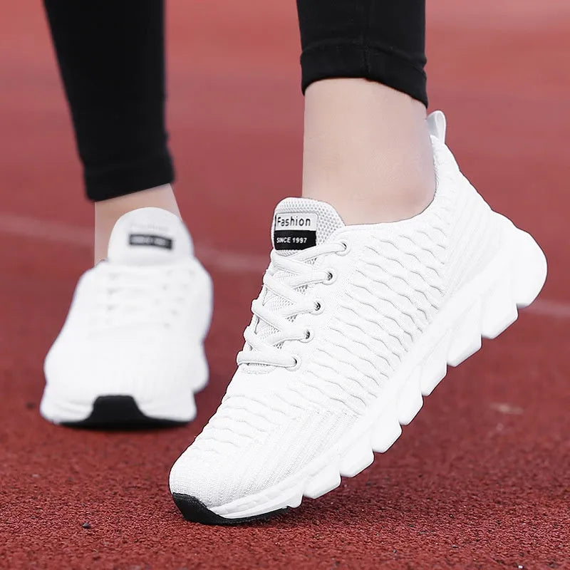Women's running shoes in black, pink, or white with a mesh upper and rubber outsole.