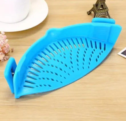 Silicone clip-on funnel strainer attached to a pot rim for draining liquids.