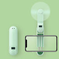 A green folding mini USB fan with plastic blades, shown in open and closed positions.