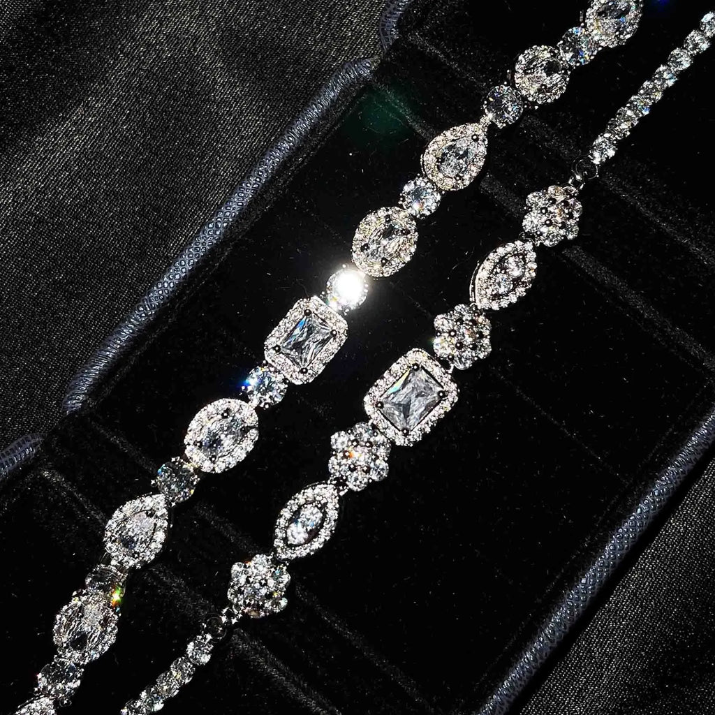 Women's geometric silver bracelet with inlaid zircon stones on a wrist, showing adjustable chain.