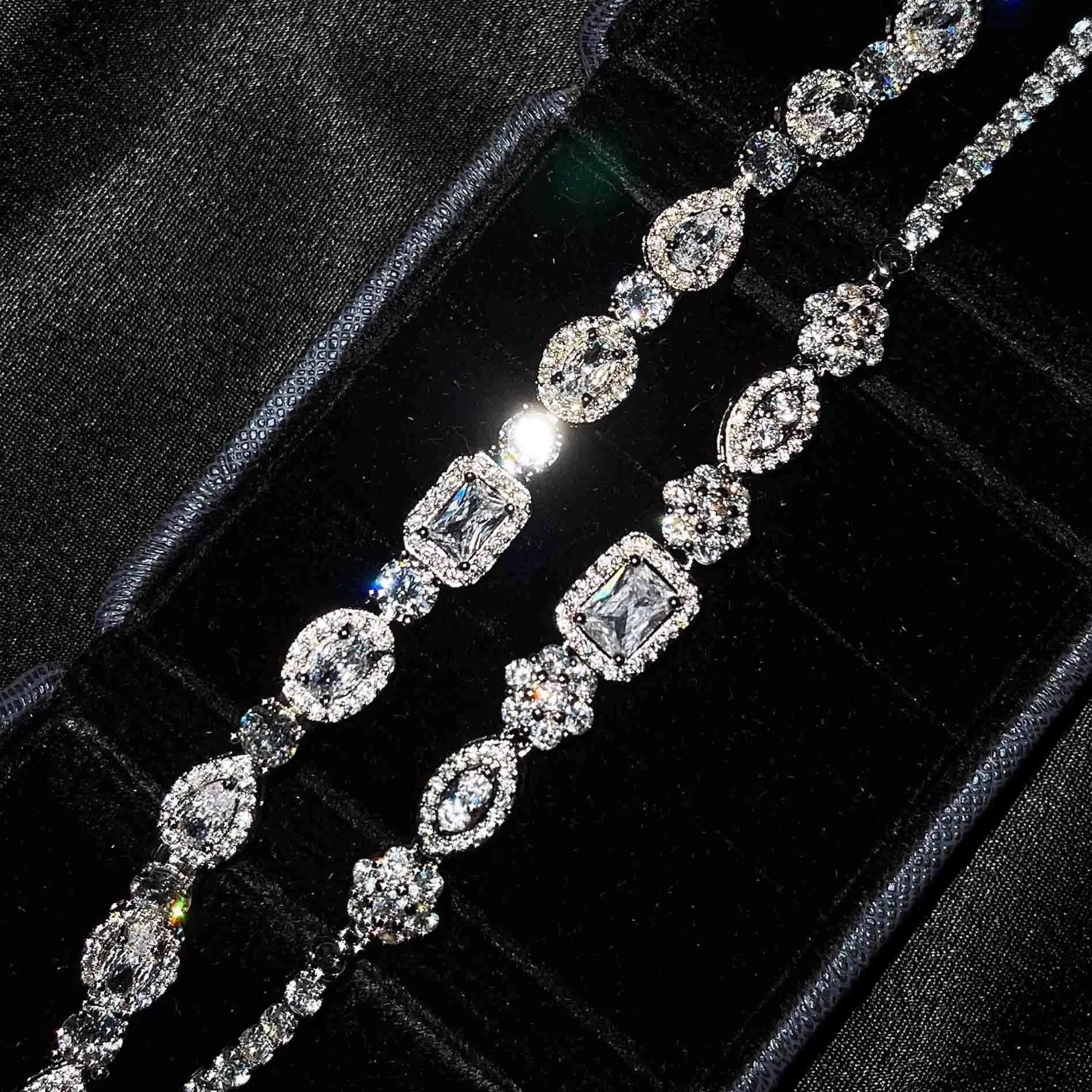 Women's geometric silver bracelet with inlaid zircon stones on a wrist, showing adjustable chain.