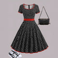 Multicolour polka dot dress with square collar, short sleeves, front zipper, and a pleated mid-length skirt on a hanger.