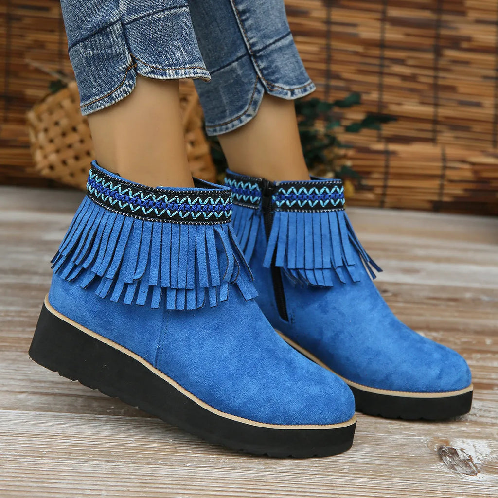 Women's suede wedge ankle boot with tassel detail, side zip, and a thick rubber sole.