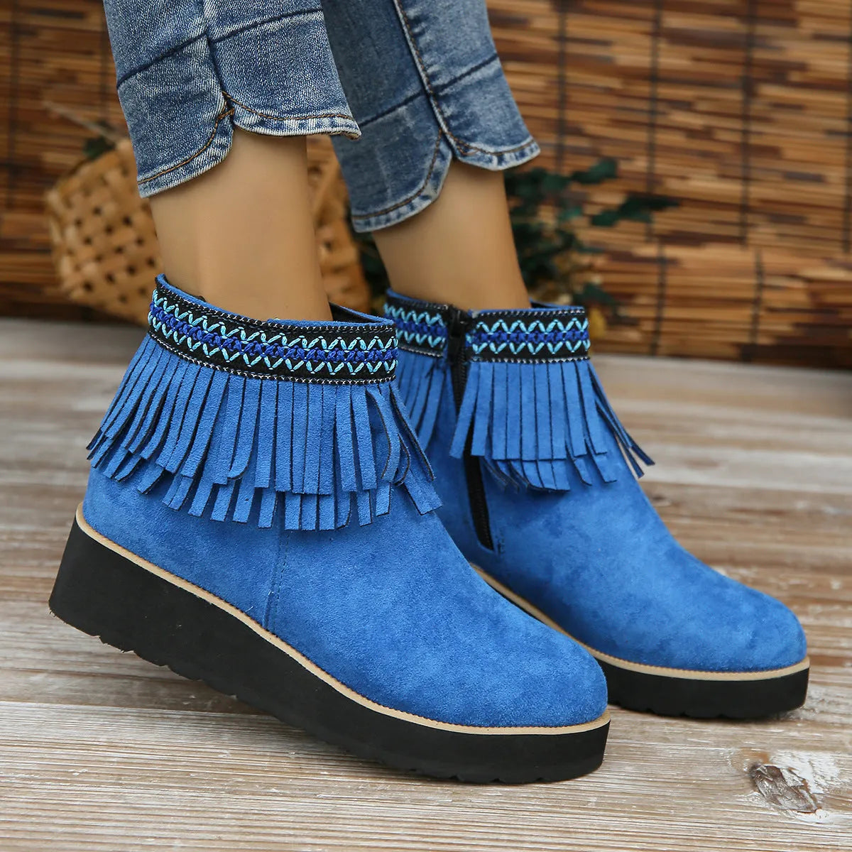 Women's suede wedge ankle boot with tassel detail, side zip, and a thick rubber sole.