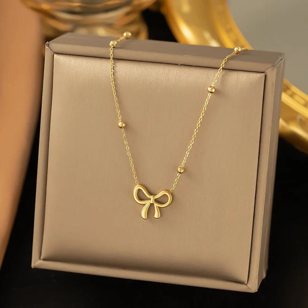 Gold bow necklace on adjustable cross chain for women
