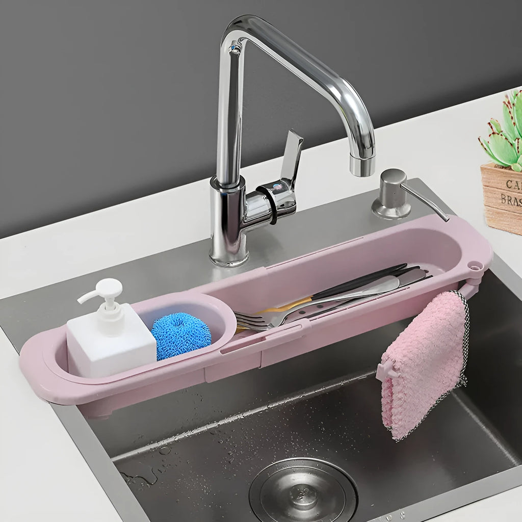 Blue grey adjustable telescopic sink rack organiser with drainer basket holding a sponge and soap bottle.