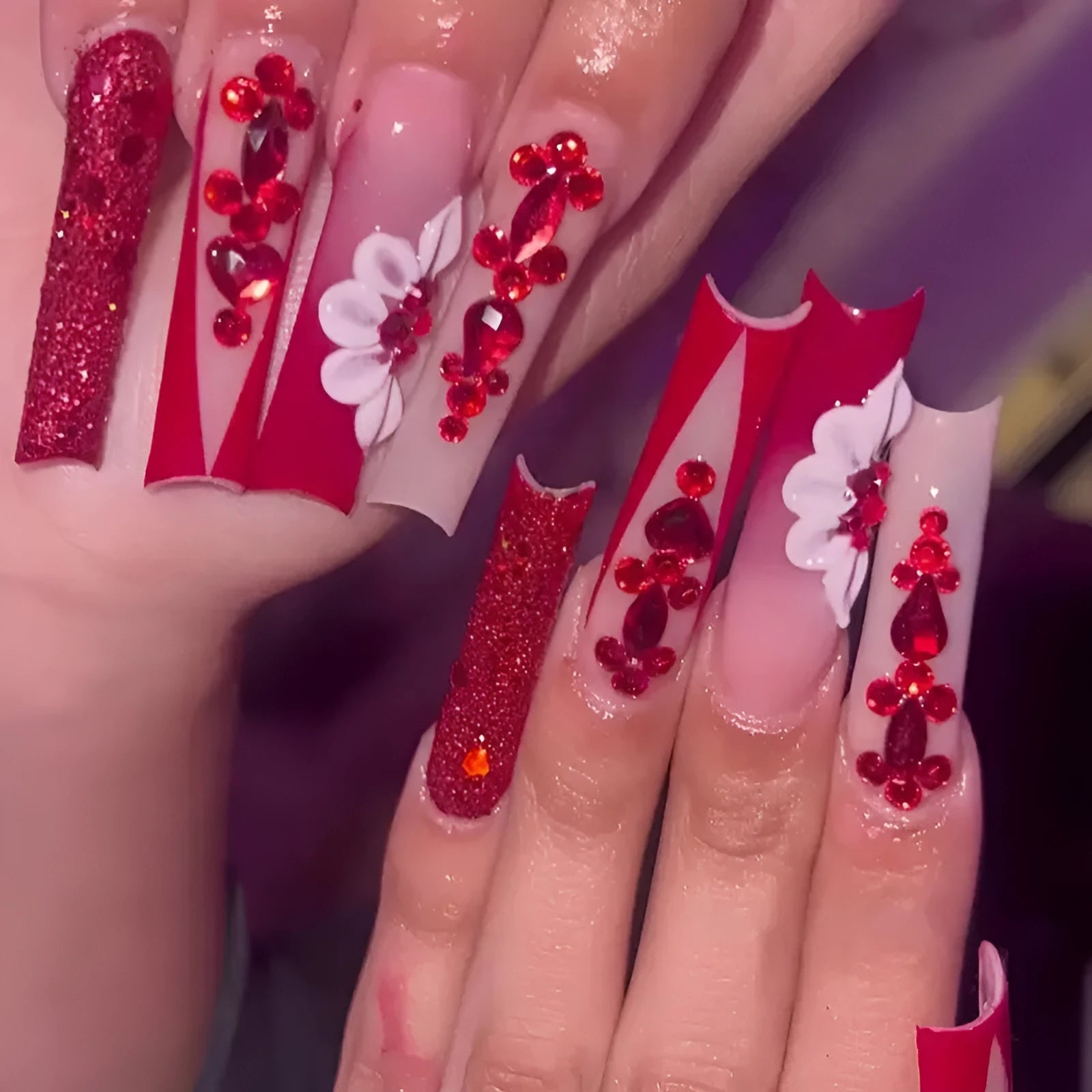 Long European square fake nails with sweet floral pattern and prismatic red diamond crystal accents.