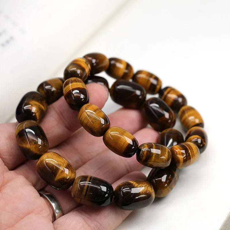 Natural yellow tigereye gemstone bracelet with ethnic constellation design on a wrist.