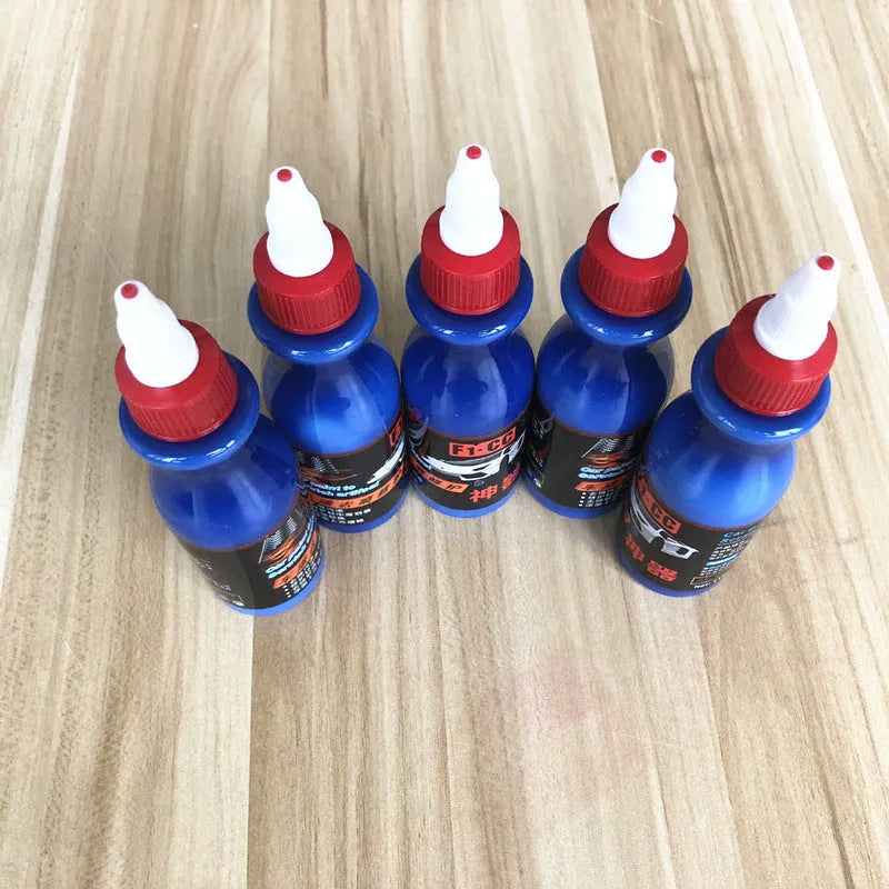 Small blue bottle of car scratch repair agent for wipe-on application to vehicle paint surfaces