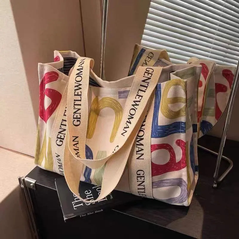 Large canvas women's tote bag with printed design, shown in available colour options.