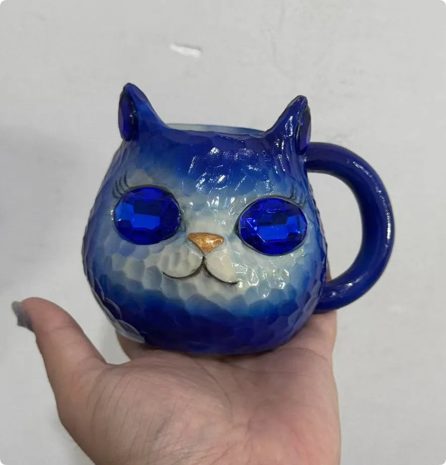 Colourful resin cat cup figurine on a shelf, shown in purple, green, blue, and pink colour options.
