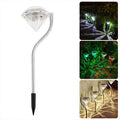 White solar-powered garden spotlight with adjustable lighting angle on a fence post.